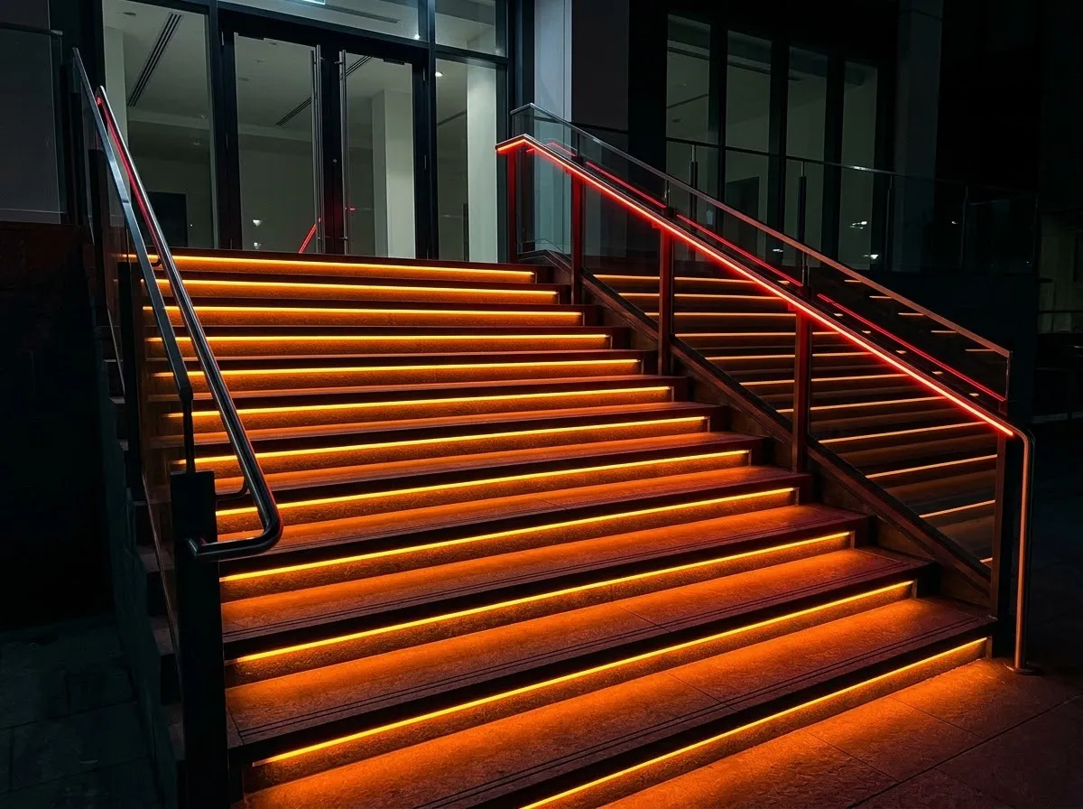階段の一段ごとの段鼻の下にオレンジのLEDテープを入れたイメージ